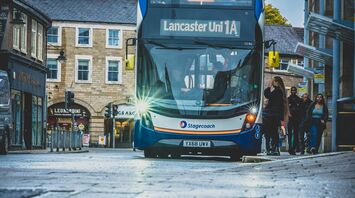 Double-decker Stagecoach bus on a wet city street with reflections in a puddle