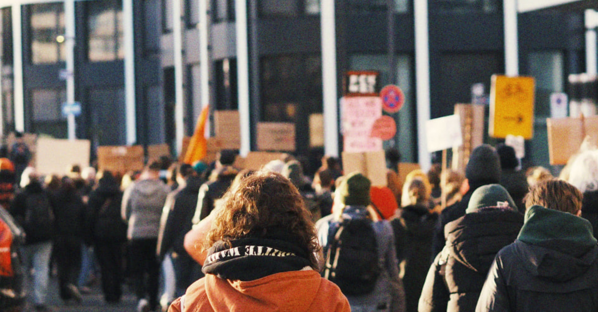 Crowd of protesters walking down a city street during a strike demonstration