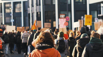 Crowd of protesters walking down a city street during a strike demonstration