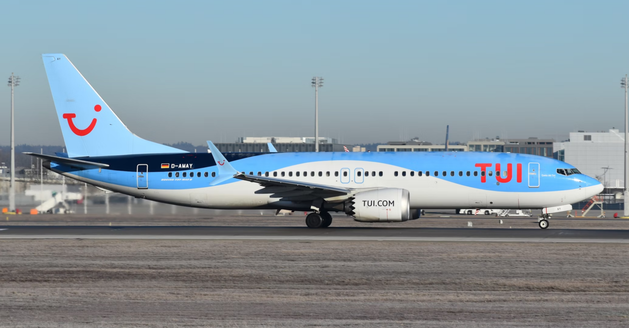 A TUI airplane on the runway at an airport, preparing for takeoff