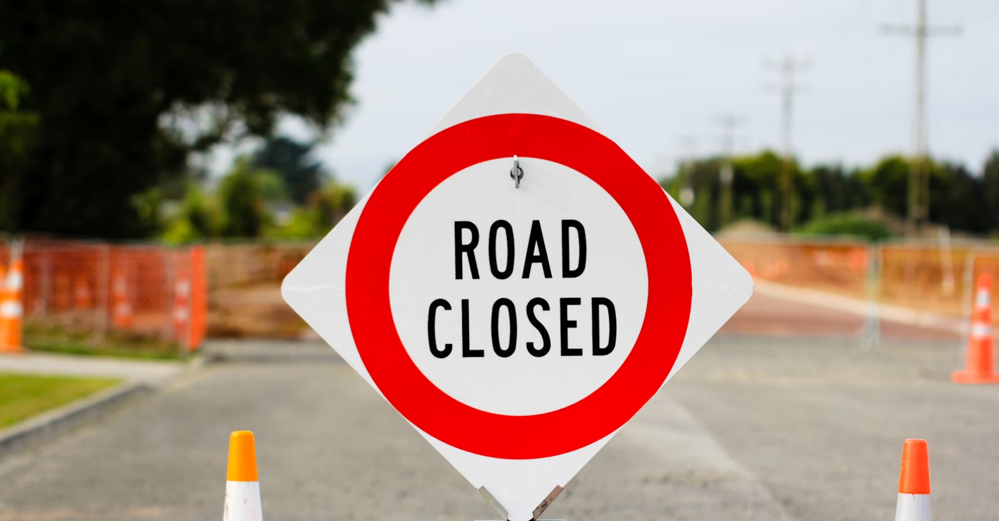 Temporary road closure sign at construction zone near airport