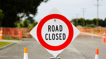 Temporary road closure sign at construction zone near airport
