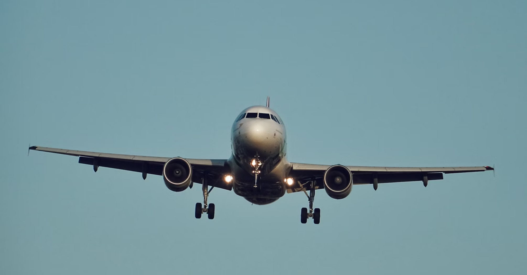 Airplane approaching runway with landing gear down