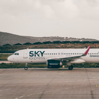 SKY express airplane on airport taxiway with mountainous background