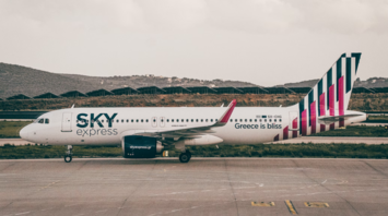 SKY express airplane on airport taxiway with mountainous background