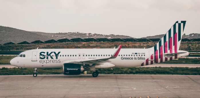 SKY express airplane on airport taxiway with mountainous background