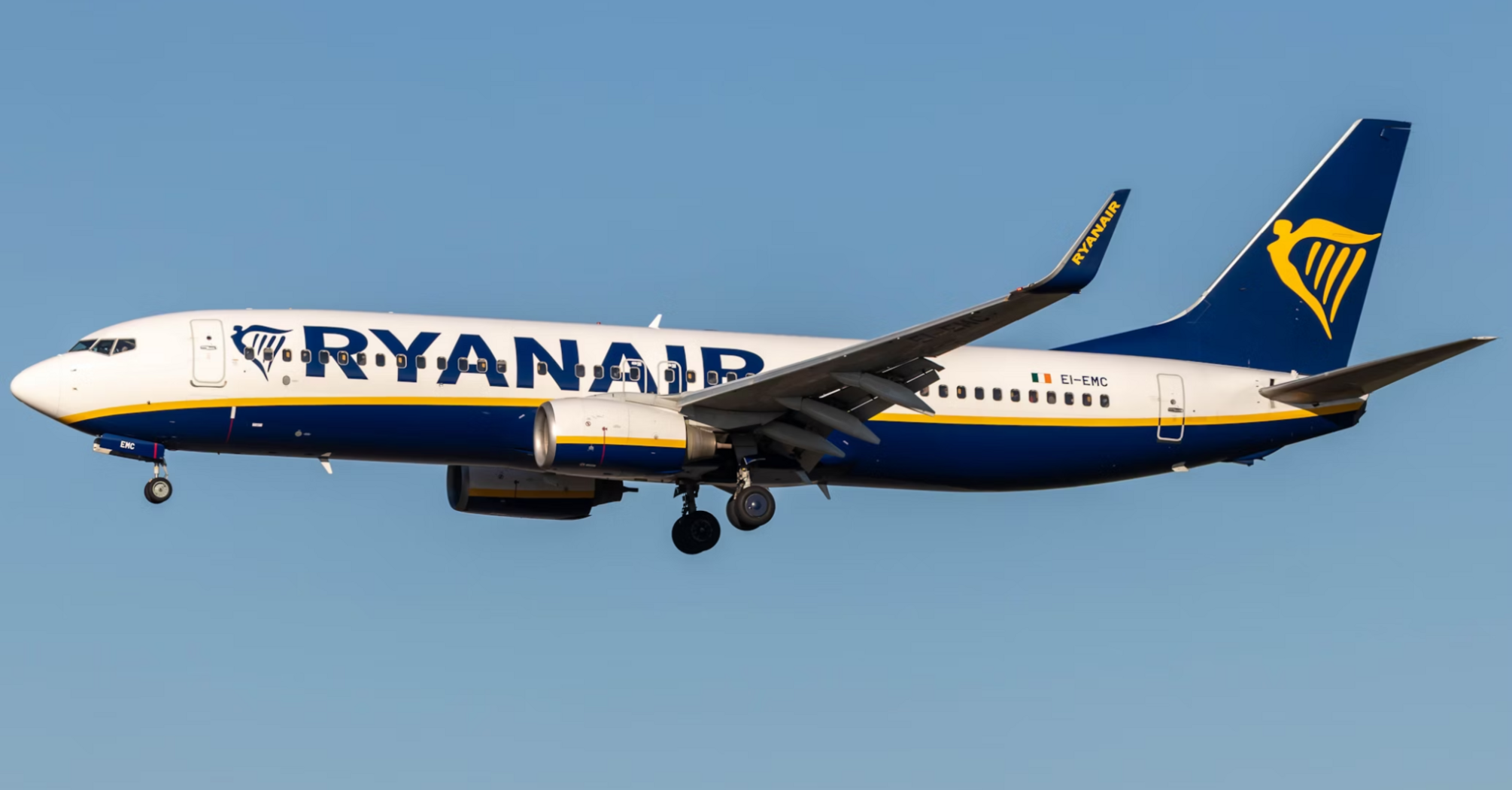 A Ryanair Boeing 737 aircraft in flight against a clear blue sky