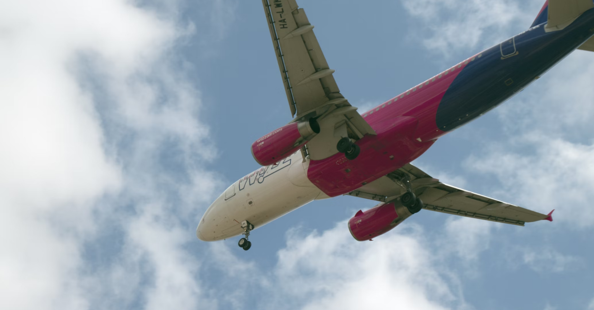 Wizz Air aircraft flying overhead with landing gear deployed