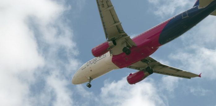 Wizz Air aircraft flying overhead with landing gear deployed