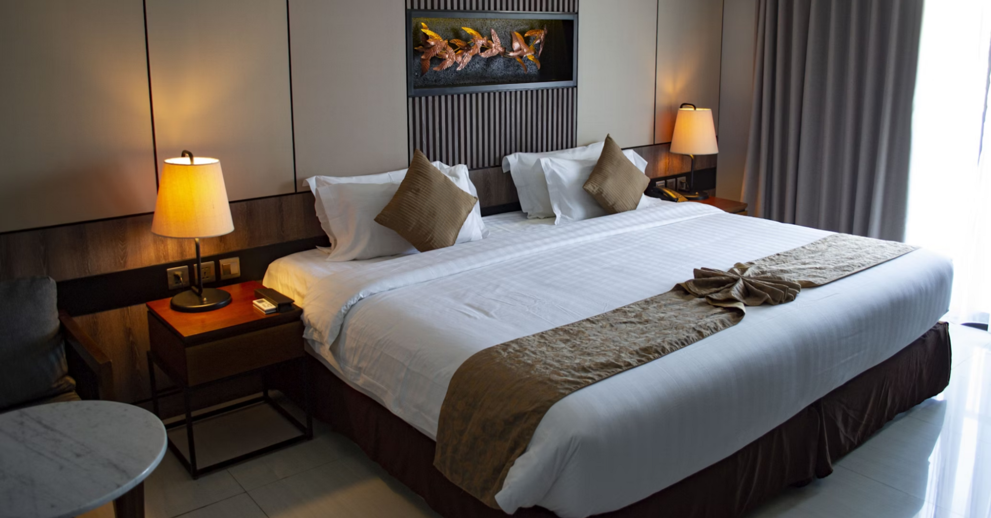 Modern hotel room with king-size bed and soft lighting