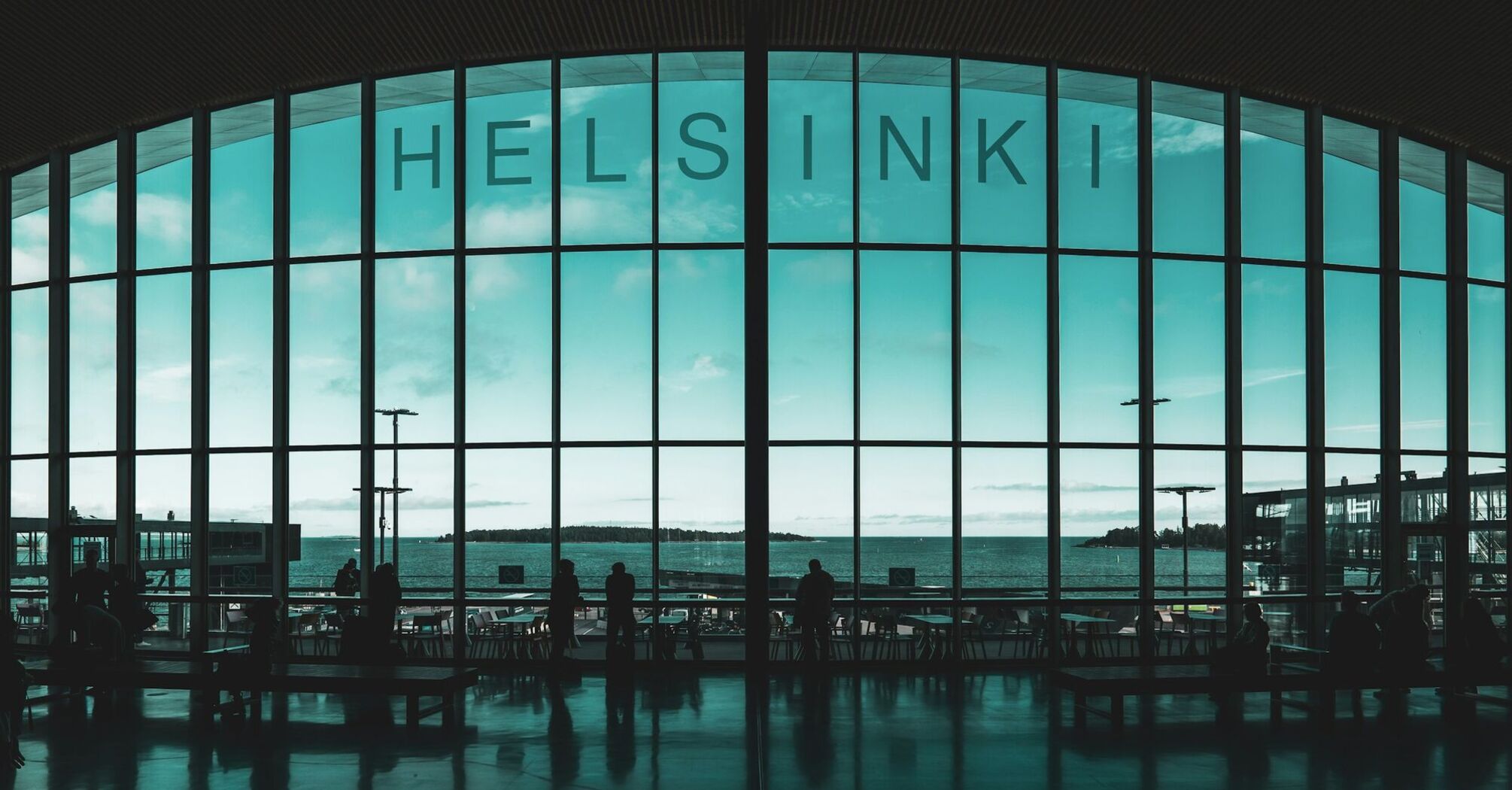 Interior of Helsinki Airport terminal with view of the sea through large windows