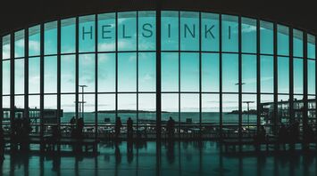 Interior of Helsinki Airport terminal with view of the sea through large windows