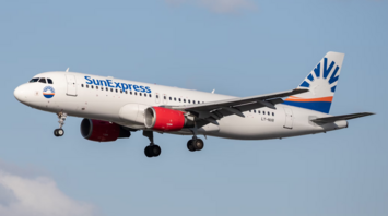 SunExpress aircraft approaching for landing against blue sky