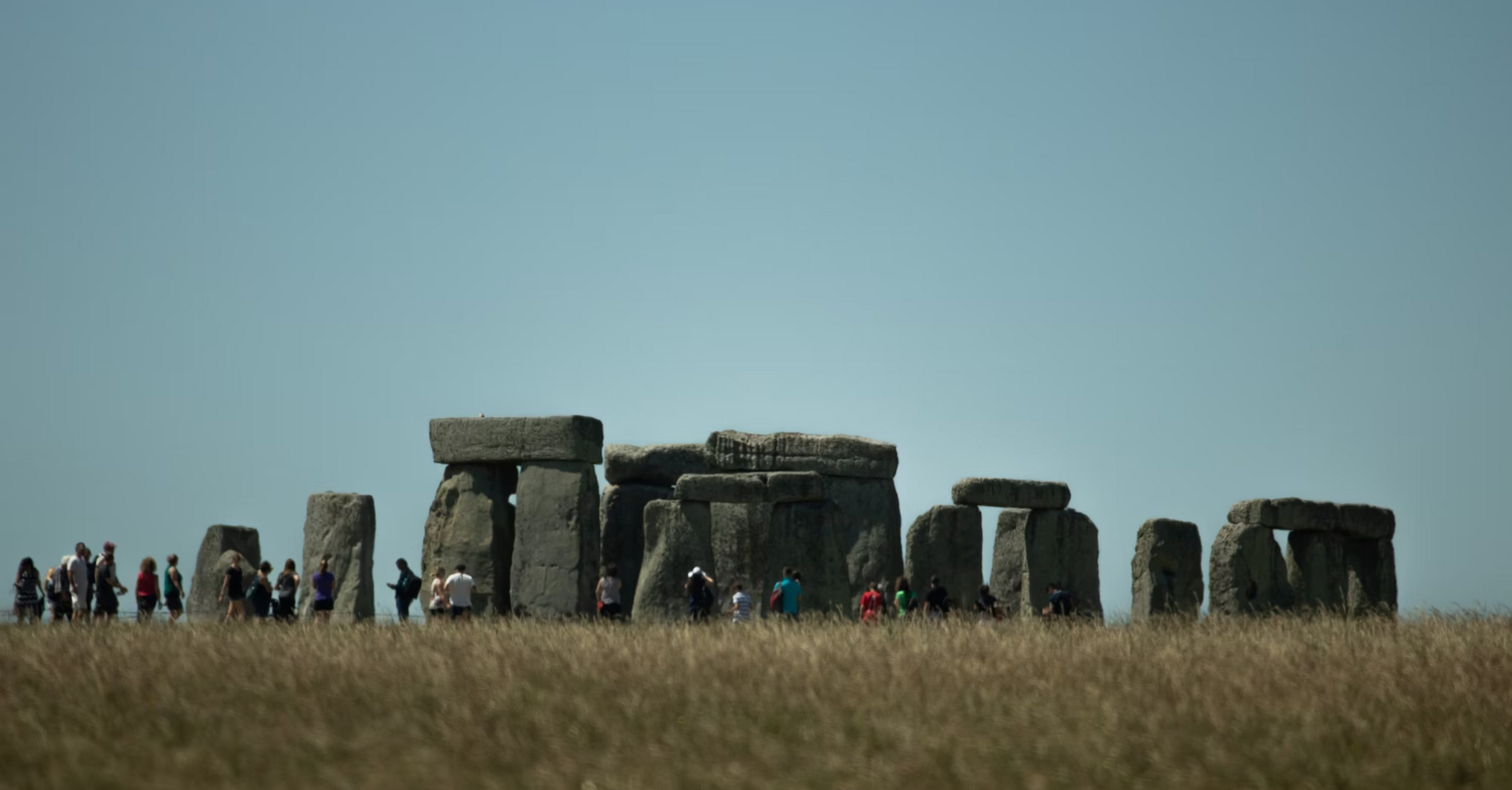 Visitors walking around Stonehenge on a clear day