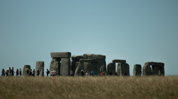 Visitors walking around Stonehenge on a clear day