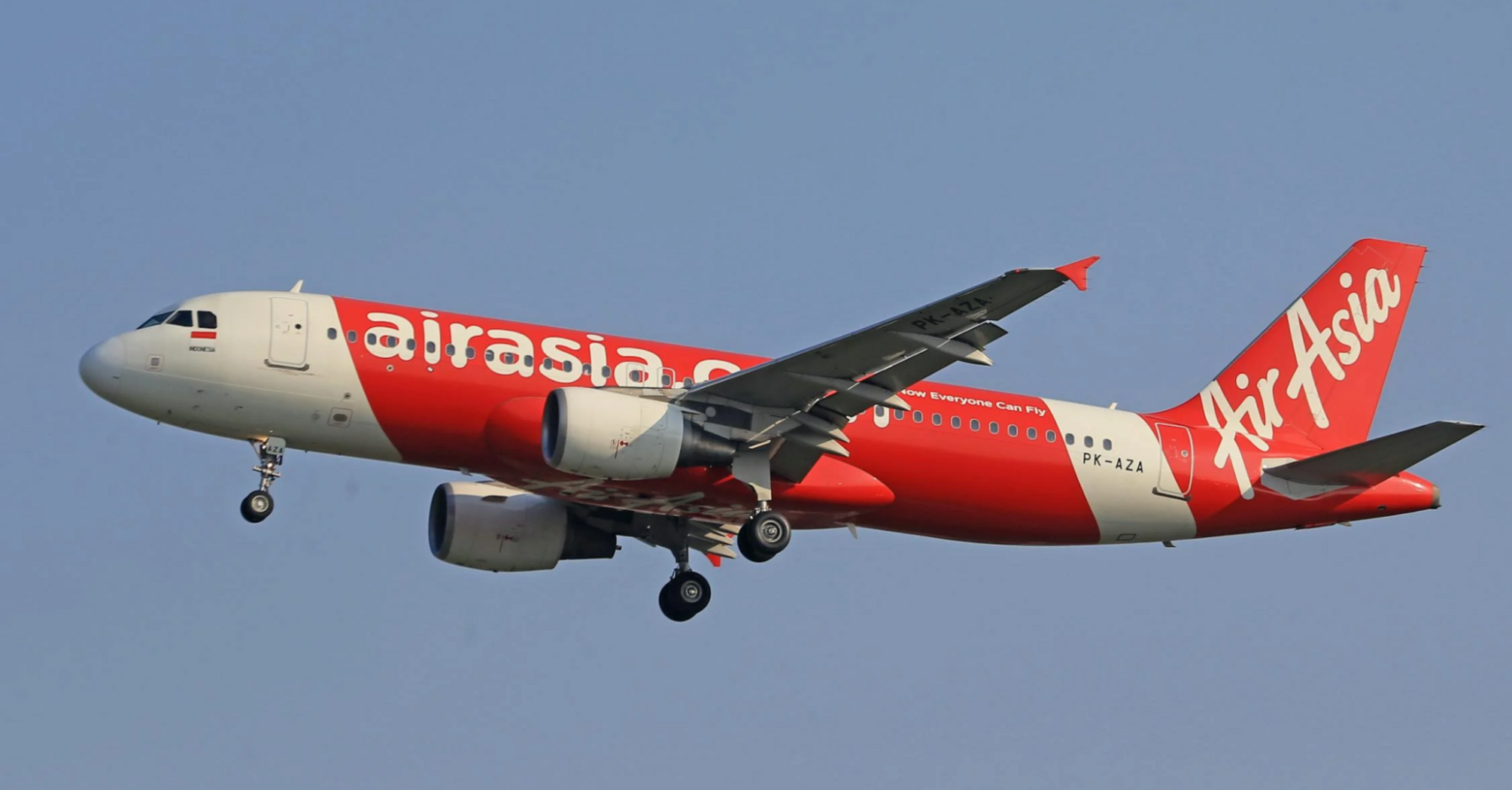 AirAsia airplane in mid-flight against blue sky