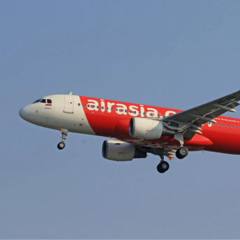 AirAsia airplane in mid-flight against blue sky