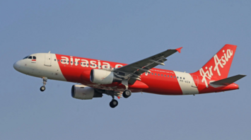 AirAsia airplane in mid-flight against blue sky
