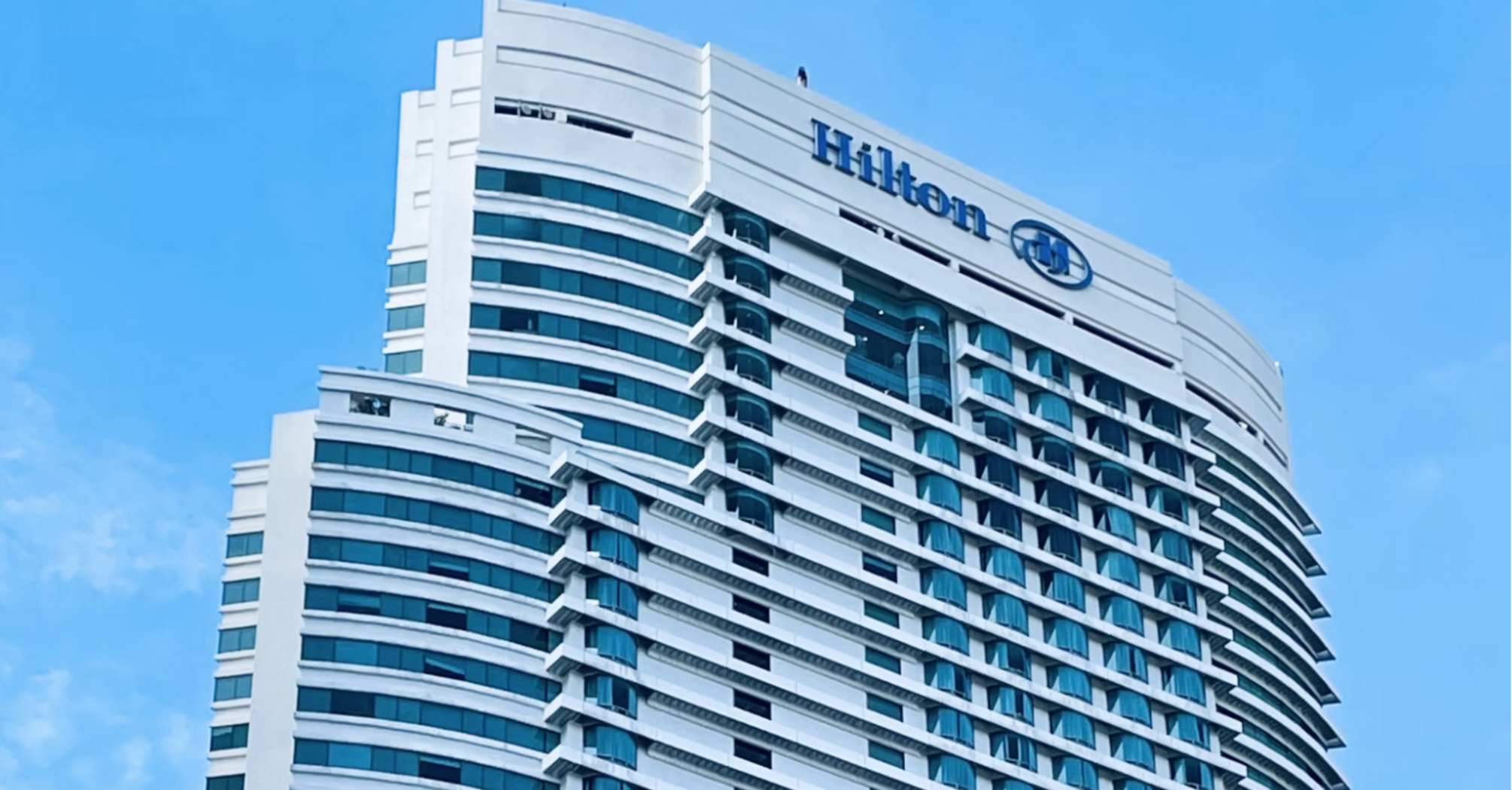Modern Hilton high-rise hotel building under blue sky