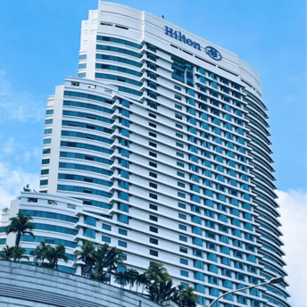 Modern Hilton high-rise hotel building under blue sky