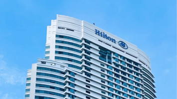 Modern Hilton high-rise hotel building under blue sky