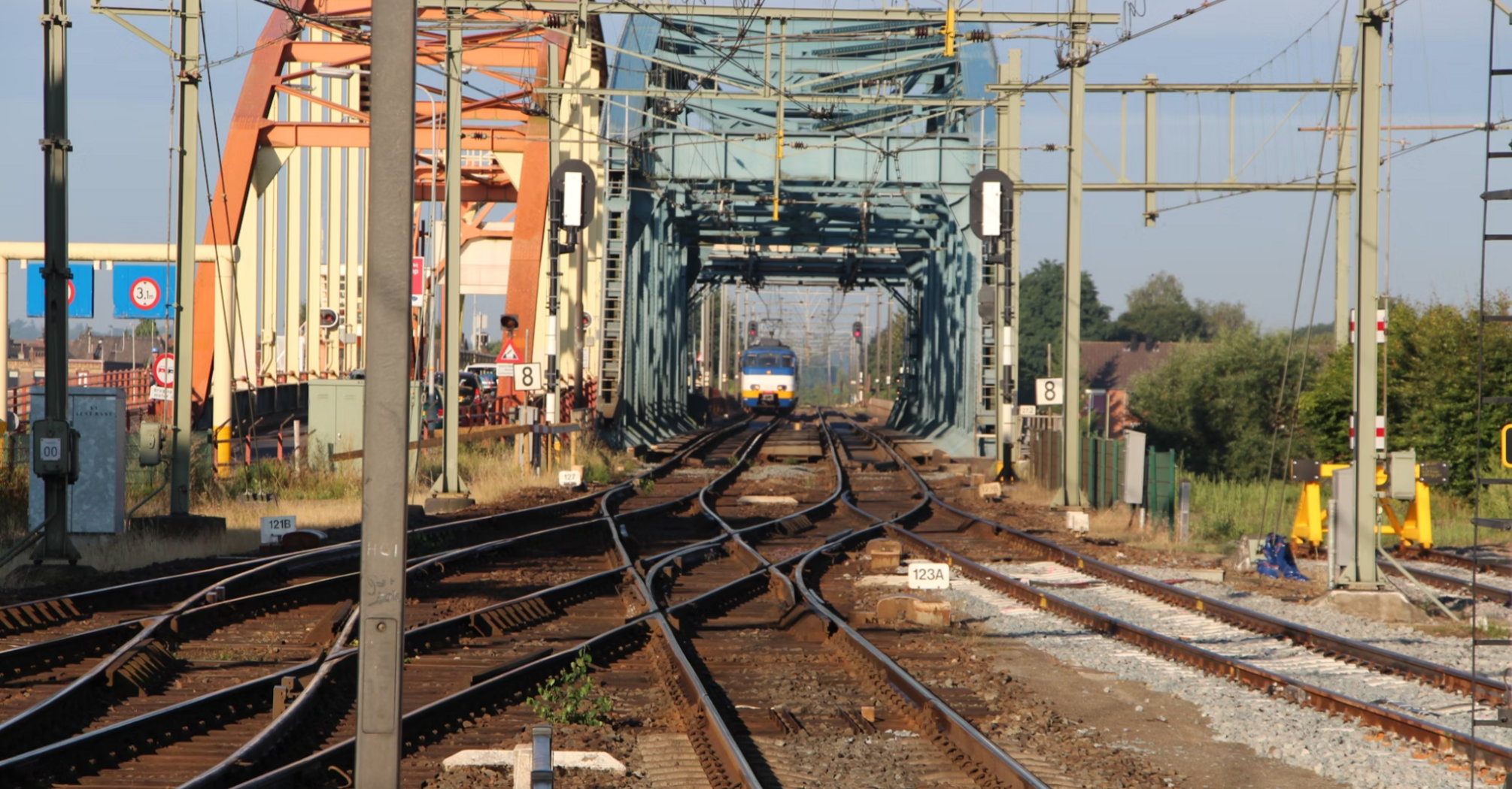 Train on electrified tracks near bridge during railway modernisation works