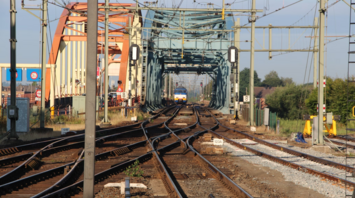 Train on electrified tracks near bridge during railway modernisation works