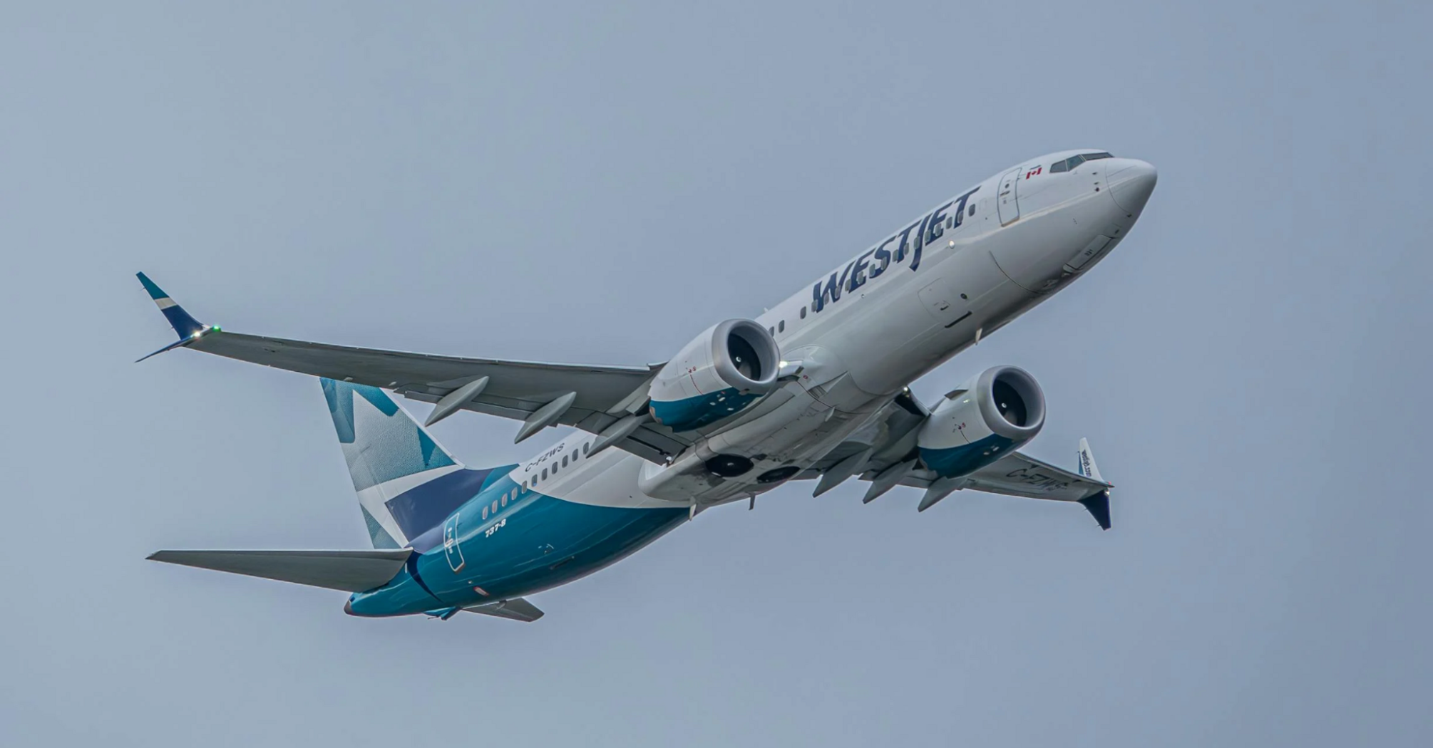 WestJet aircraft in flight against a grey sky