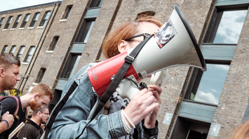 Person holding a megaphone at a protest or demonstration