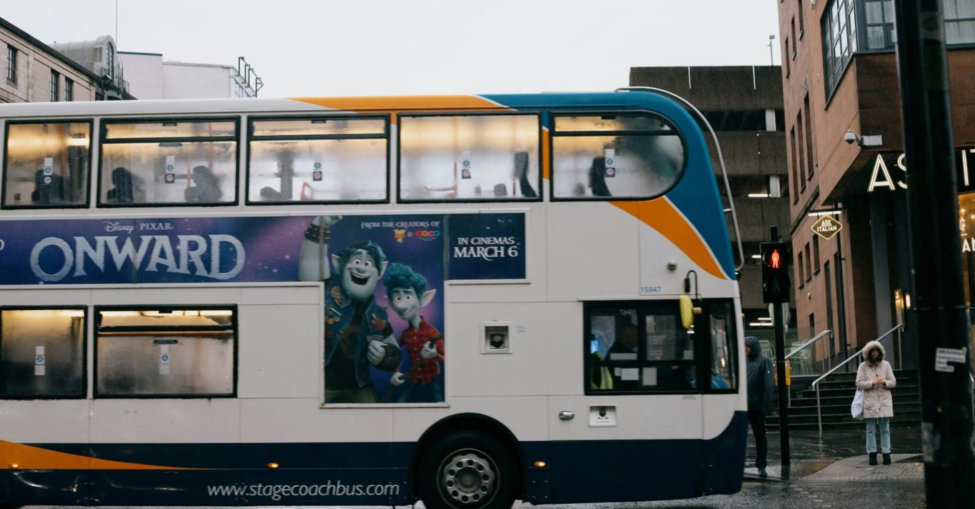 Stagecoach double-decker bus passing through rainy city street