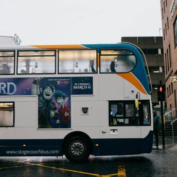 Stagecoach double-decker bus passing through rainy city street