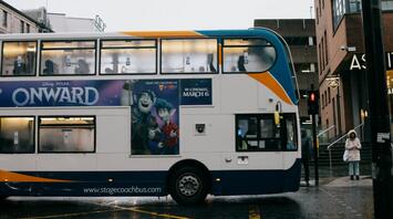 Stagecoach double-decker bus passing through rainy city street