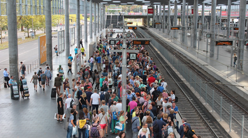 Crowd of passengers waiting on a busy train platform