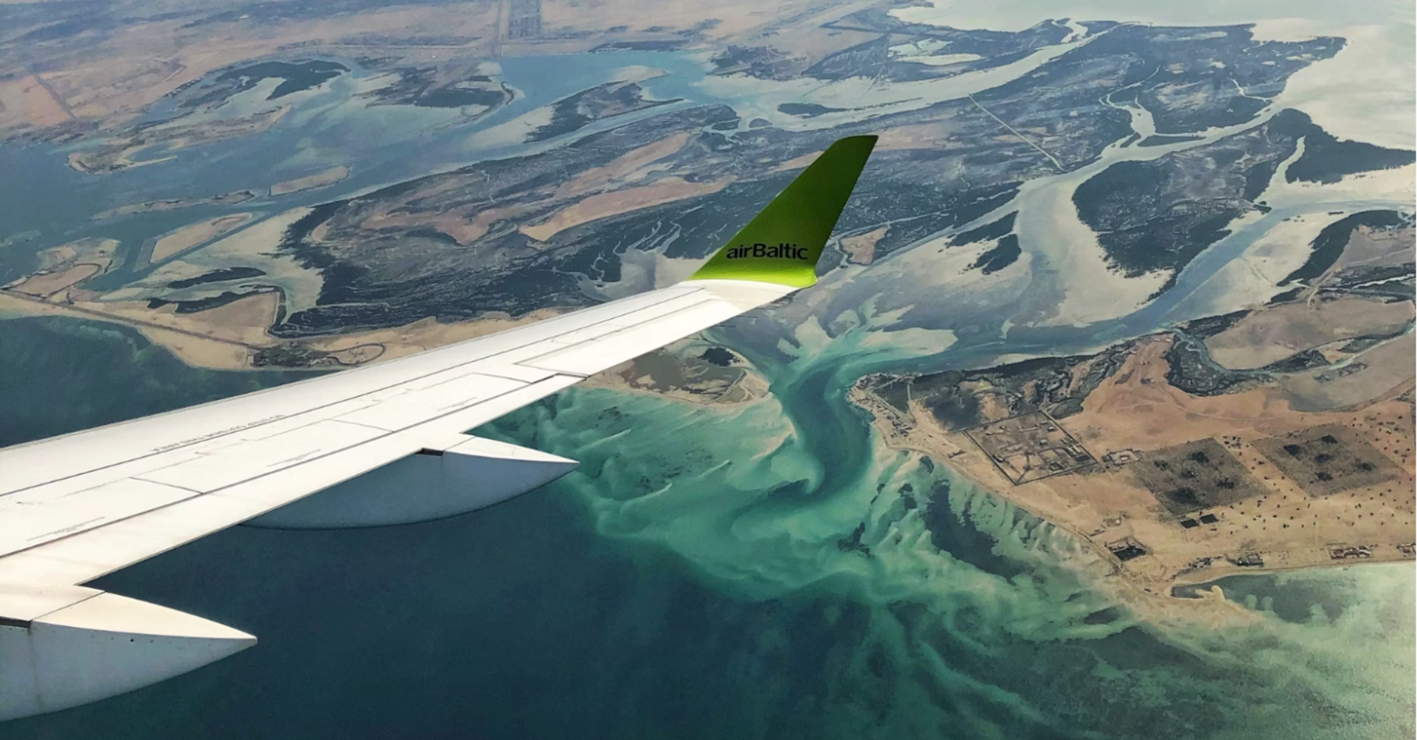 View from airBaltic wing over coastal waters