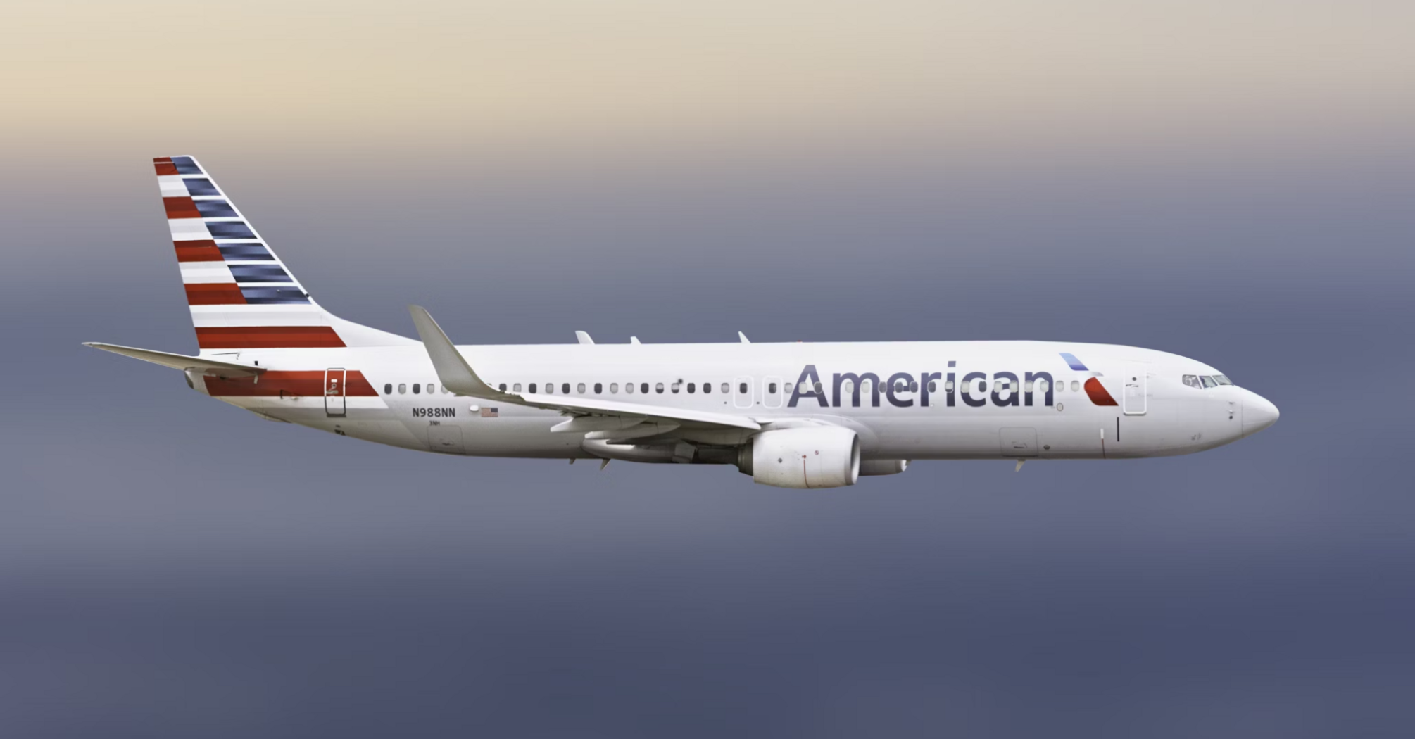 American Airlines aircraft in mid-flight against a dusky sky