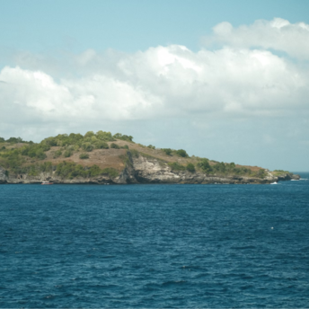 Rocky shoreline of a small uninhabited island with sparse vegetation and steep coastal cliffs