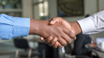 Two people shaking hands in a professional setting