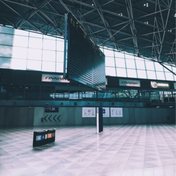 Empty departure hall at Helsinki Airport with Finnair signs and a blank flight board
