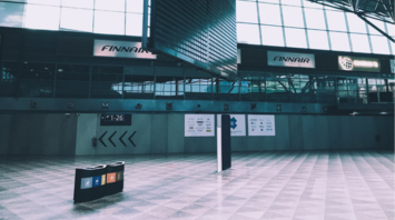 Empty departure hall at Helsinki Airport with Finnair signs and a blank flight board