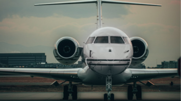 Front view of a small passenger jet on a runway during sunset