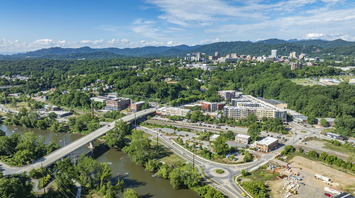 Aerial view of Asheville’s River Arts District surrounded by greenery and mountains