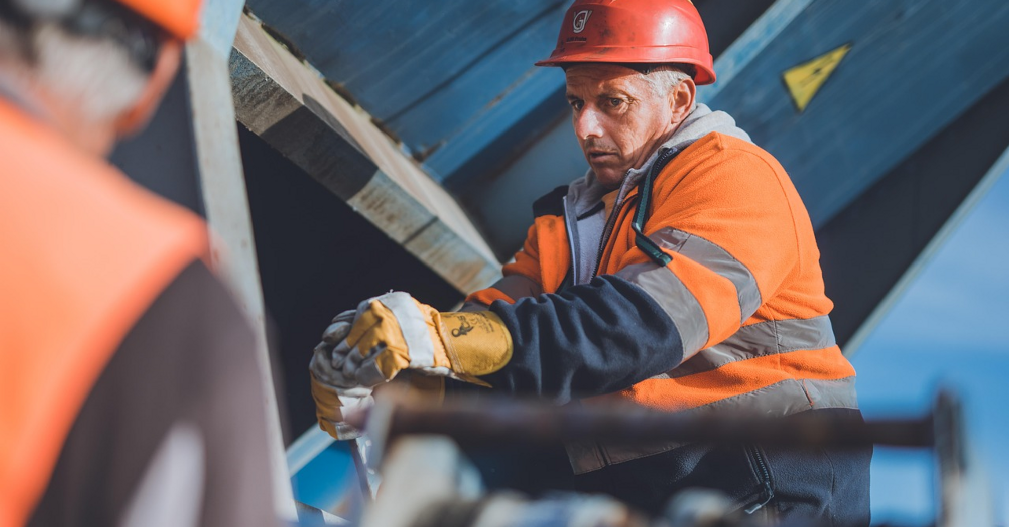 Construction worker in high-visibility gear at a rail infrastructure site