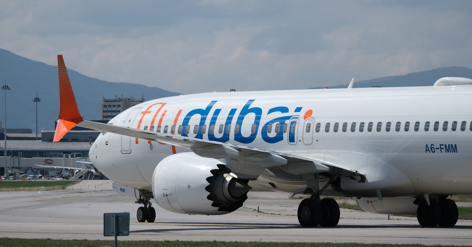 flydubai aircraft on runway near terminal building