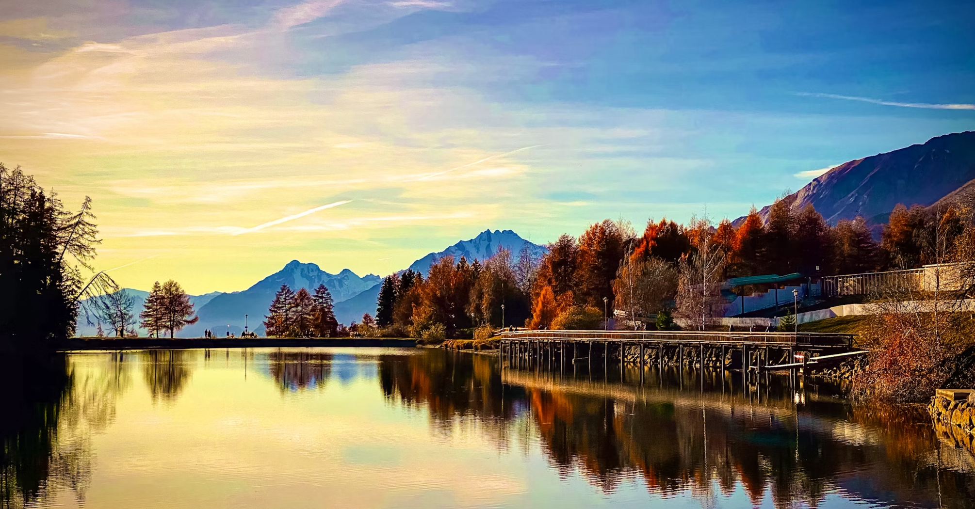 Peaceful alpine lake reflecting autumn trees and mountains in Crans-Montana, Swiss Alps