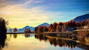 Peaceful alpine lake reflecting autumn trees and mountains in Crans-Montana, Swiss Alps