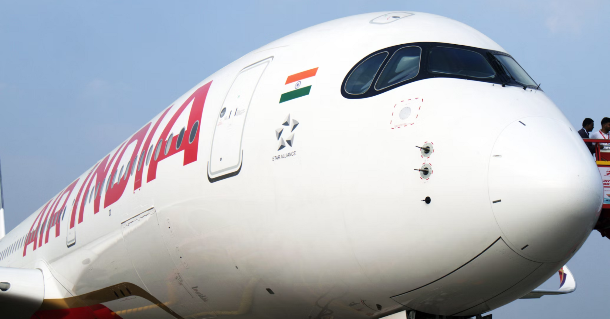 Close-up of an Air India aircraft at the airport gate with ground crew nearby