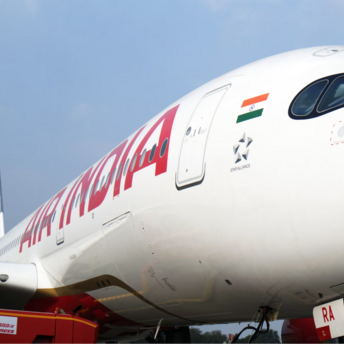 Close-up of an Air India aircraft at the airport gate with ground crew nearby