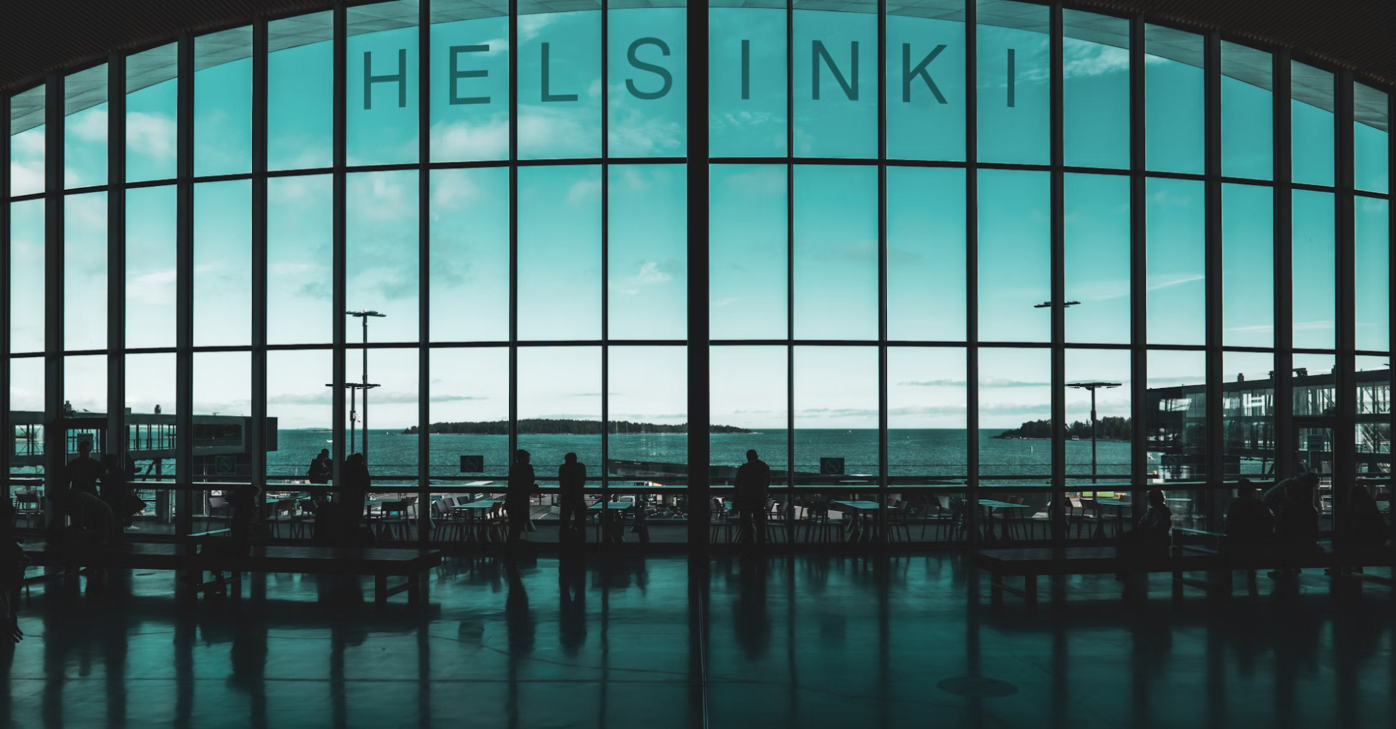 Interior of Helsinki Airport terminal with silhouetted passengers