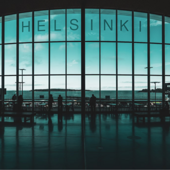 Interior of Helsinki Airport terminal with silhouetted passengers