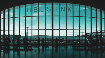 Interior of Helsinki Airport terminal with silhouetted passengers